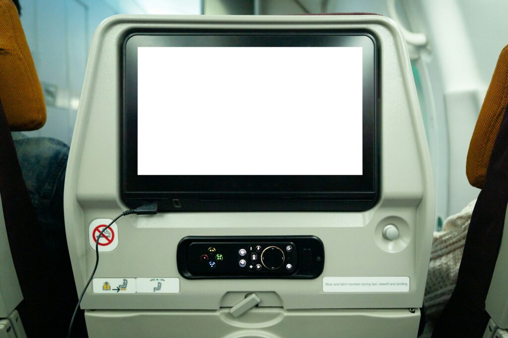 a computer monitor sitting on top of an airplane seat