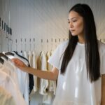 A Woman in White Shirt Choosing from the Wardrobe